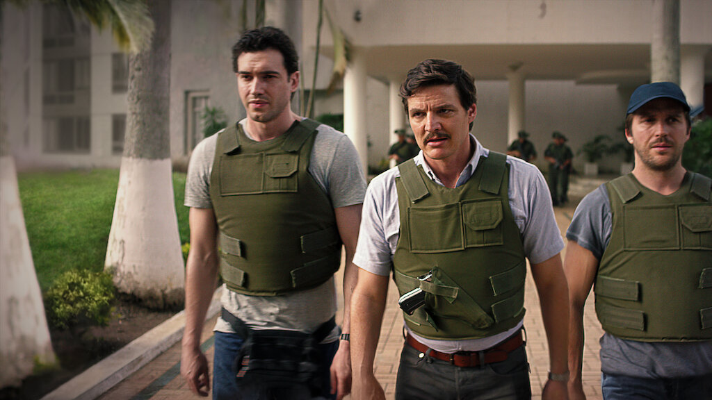 Narcos characters walking in tactical vests, led by Pedro Pascal's character.