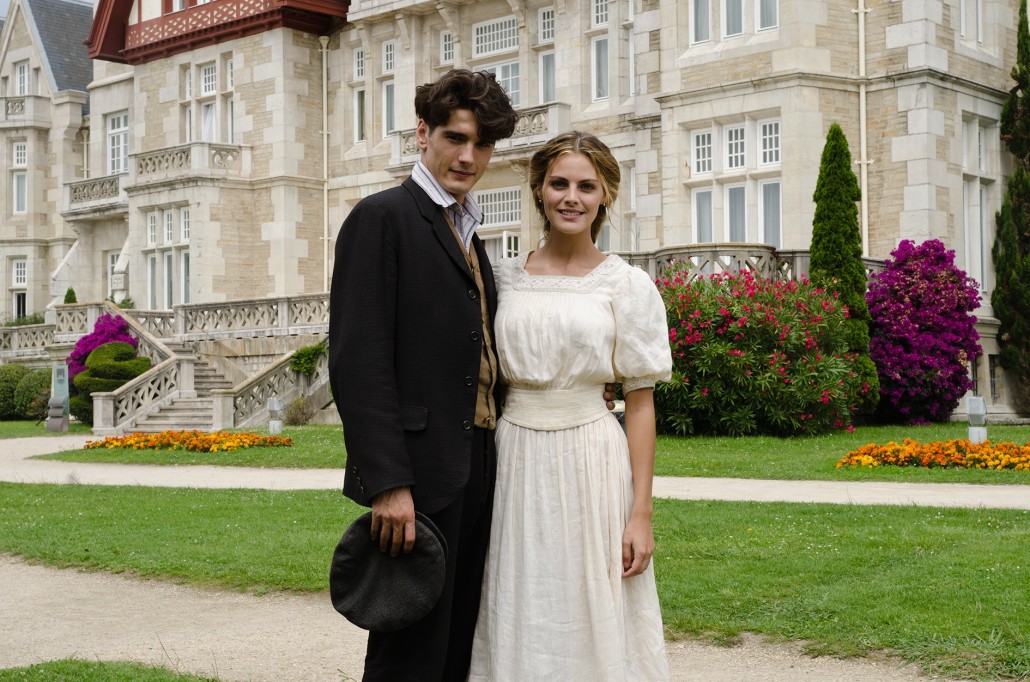 The lead characters from Gran Hotel standing in front of a grand mansion.