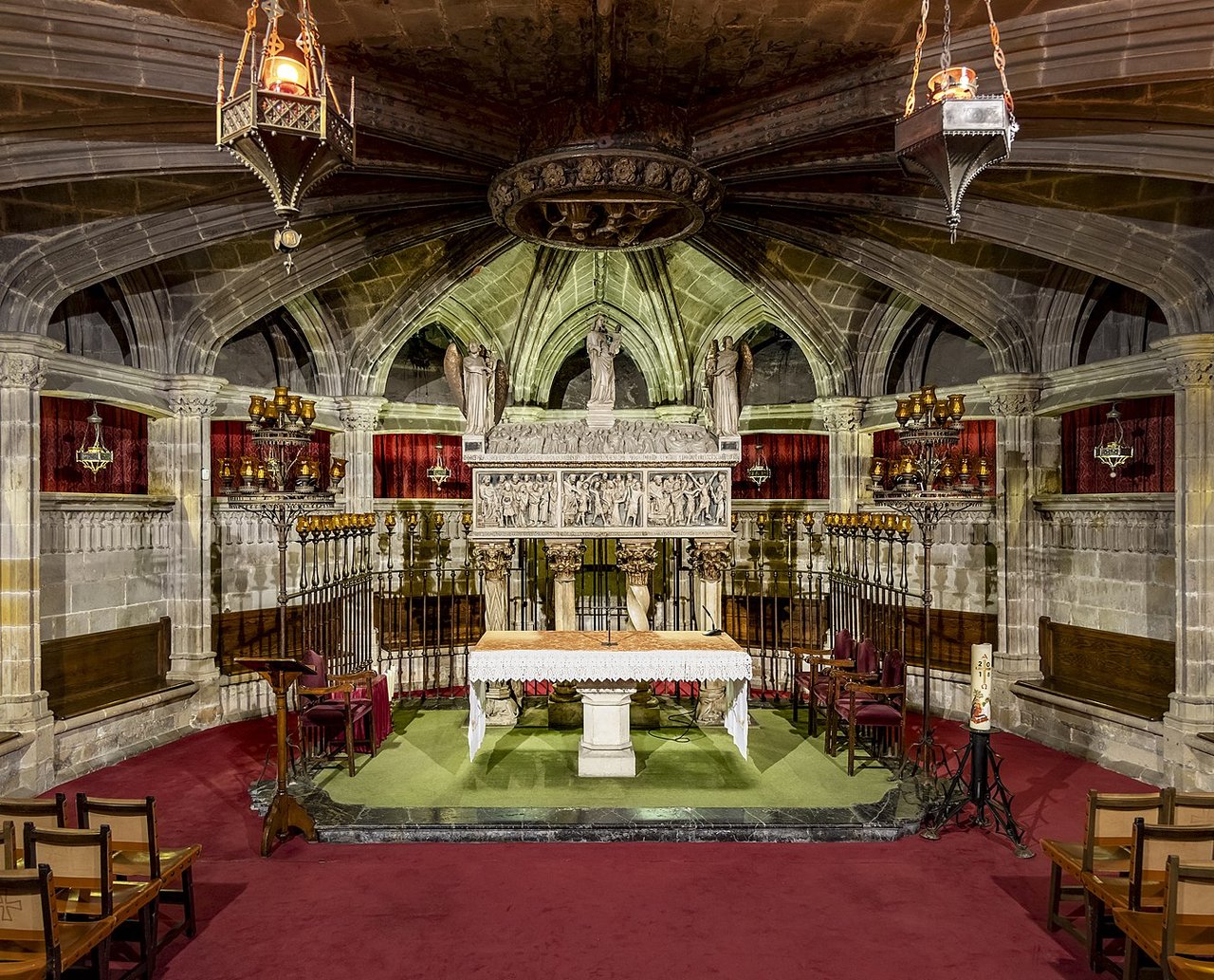 Crypt of Santa Eulalia inside Barcelona Cathedral featuring an ornate altar and Gothic architecture