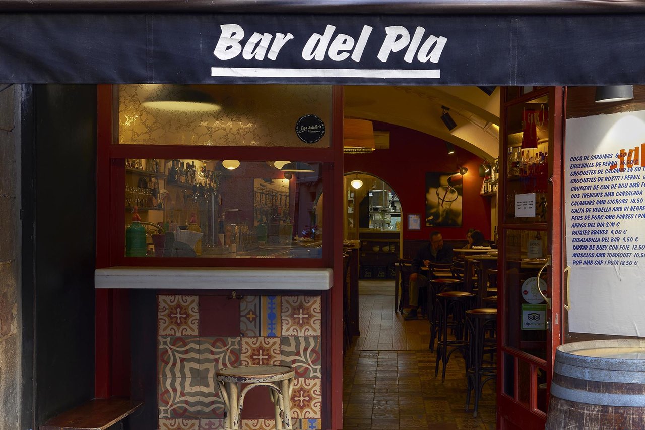 Front entrance of Bar del Pla in Barcelona with a view of its interior and tiled decor.