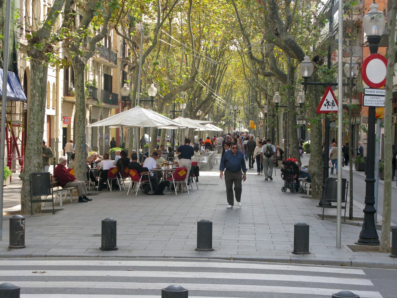 Rambla poblenou in Barcelona, with people sitting outside