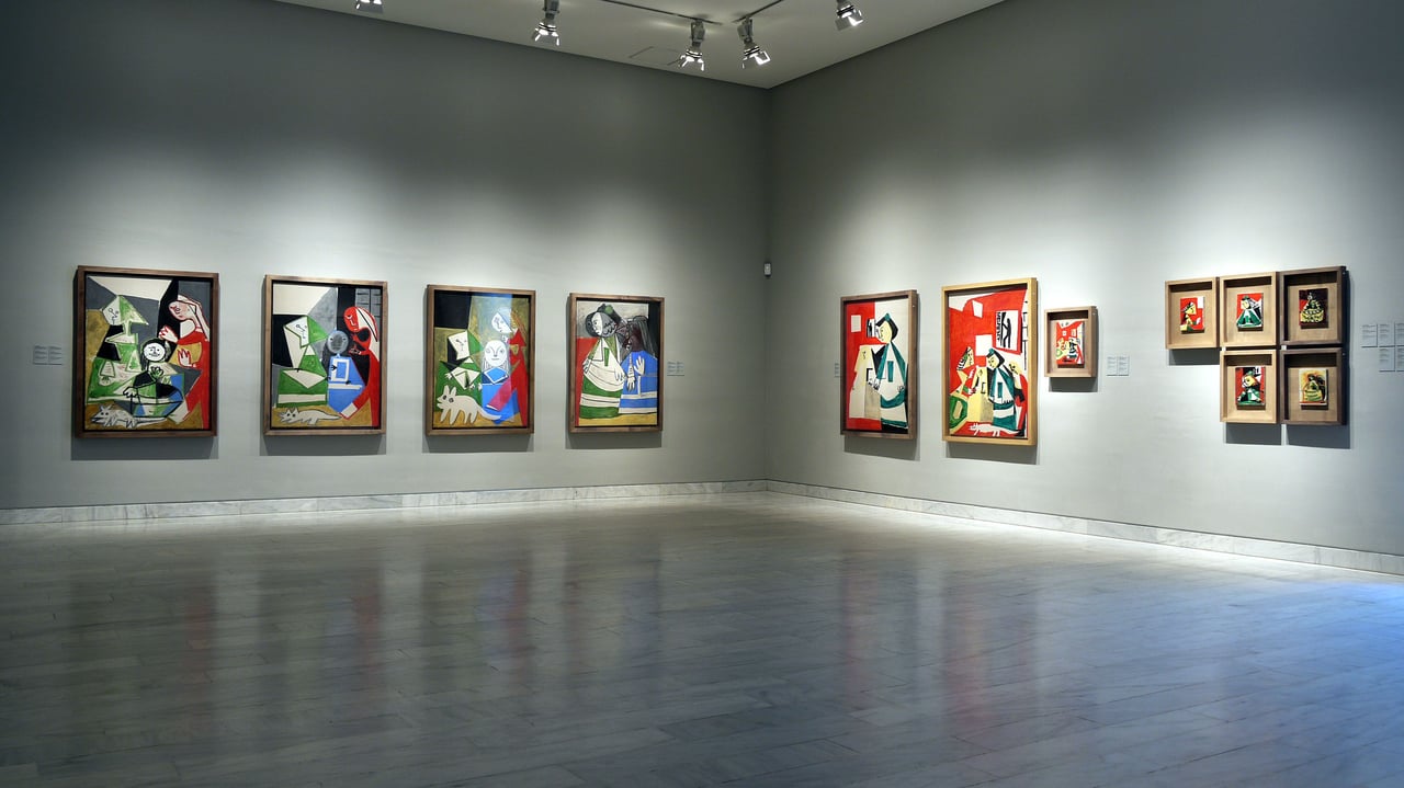 Art gallery exhibit at the Picasso Museum in Barcelona, displaying a collection of colorful cubist paintings by Pablo Picasso.