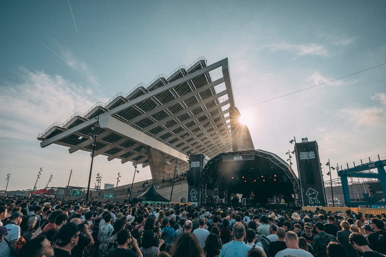 Large crowd attending an outdoor concert at Primavera Sound in Barcelona, with a modern architectural structure in the background
