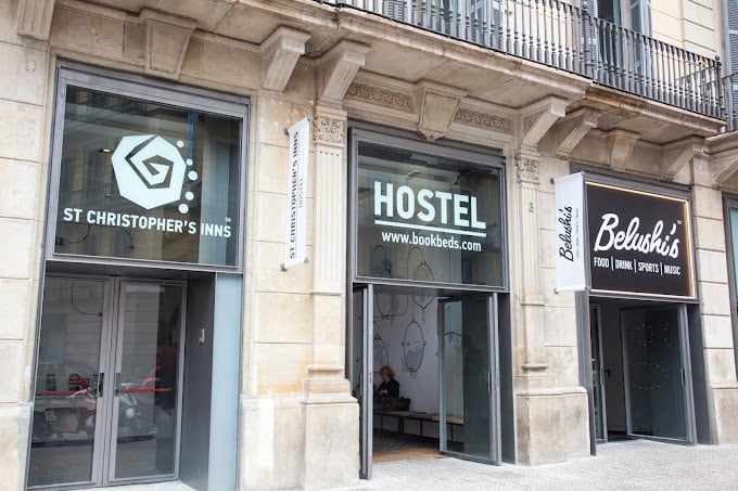 Front view of St Christopher's Inns Hostel in Barcelona, featuring large glass windows and entrance.