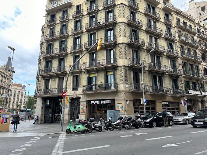 Facade of Sleep Green Hostel in Barcelona, with Pai Mei restaurant nearby.