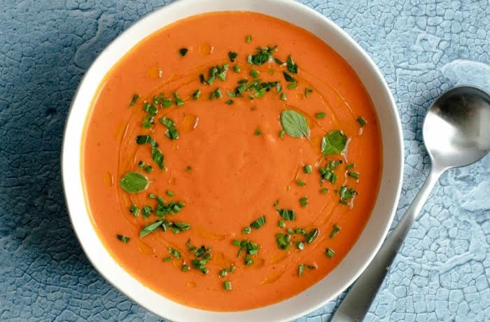 Bowl of Gazpacho, a traditional Spanish cold tomato soup, garnished with fresh herbs and a drizzle of olive oil.