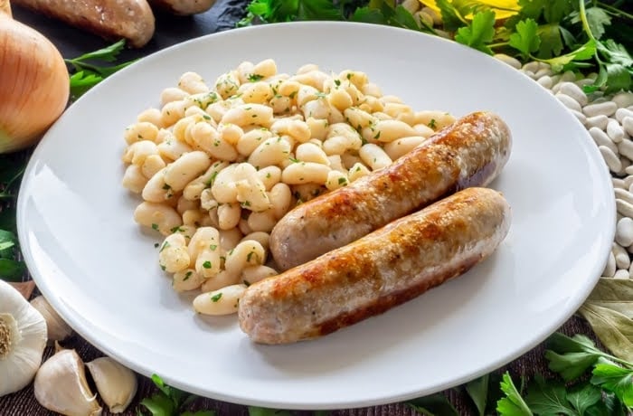 Plate of Butifarra sausages served with white beans, a traditional Catalan dish.