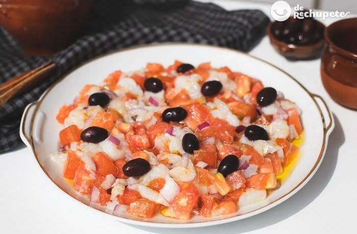 Esqueixada, a traditional Catalan salad made with shredded salt cod, tomatoes, onions, and black olives.