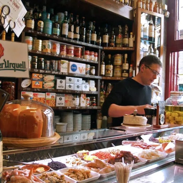 Inside of quimet & quimet tapas bar, employee preparing the tapas