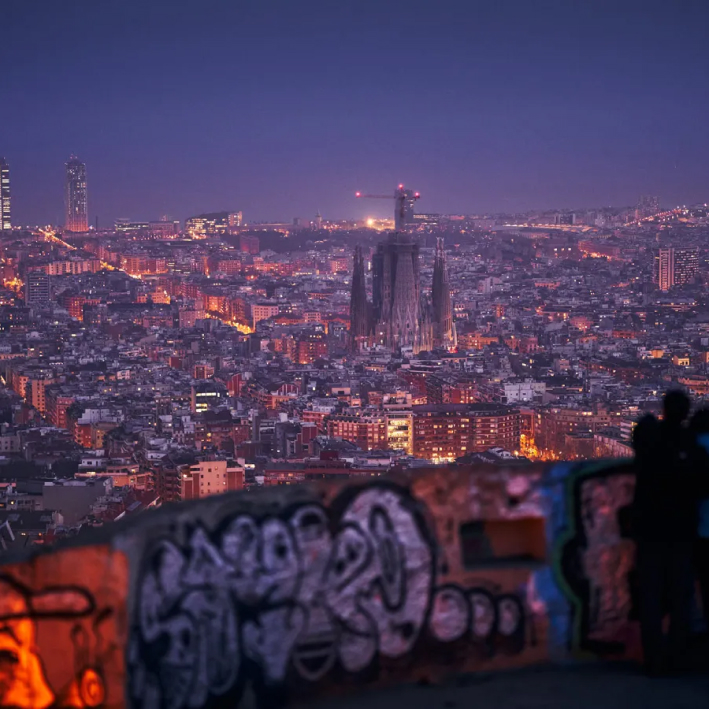 Nighttime panoramic view of Barcelona from Bunkers del Carmel, highlighting the city lights and skyline.