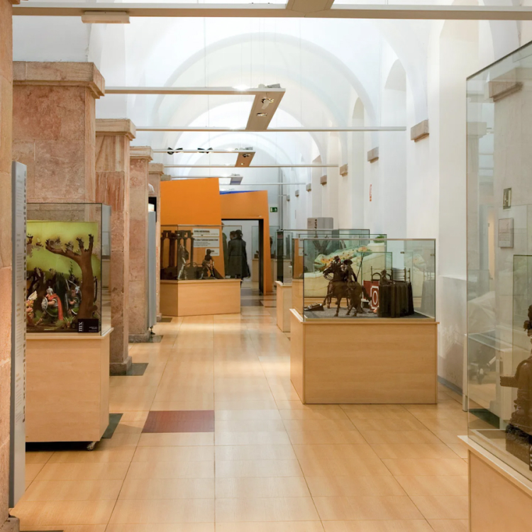 Exhibits at the Chocolate Museum in Barcelona, featuring chocolate sculptures and art displays in glass cases.