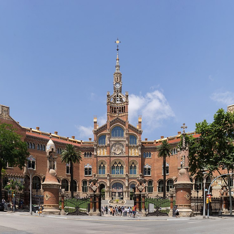 Facade of the historic Sant Pau Hospital in Barcelona, showcasing its stunning architecture and central clock tower.
