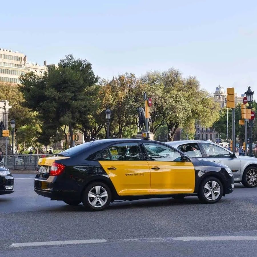 Black and yellow barcelona taxi driving in the city