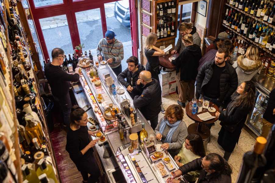 Quimet & Quimet tapas bar in Barcelona with a bustling crowd enjoying food and drinks at the counter.