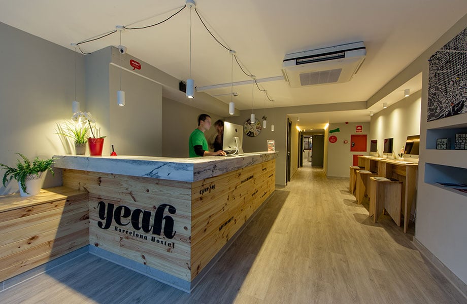 Reception area of Yeah Hostel in Barcelona with wood-themed design.