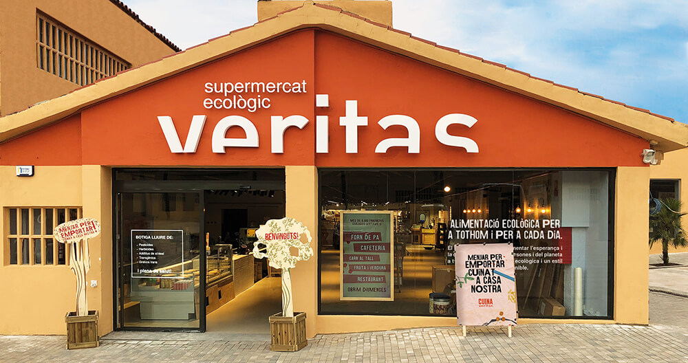 Exterior of Veritas eco-friendly supermarket in Barcelona with large signage and welcoming entrance.