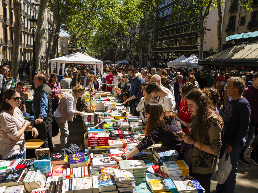 Crowds of people browsing books at a street market on Sant Jordi's Day in Barcelona.