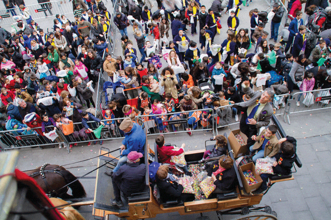 Crowds gather during the Sant Medir Festival in Barcelona, where horse-drawn carriages throw candy to children as part of the traditional celebration.