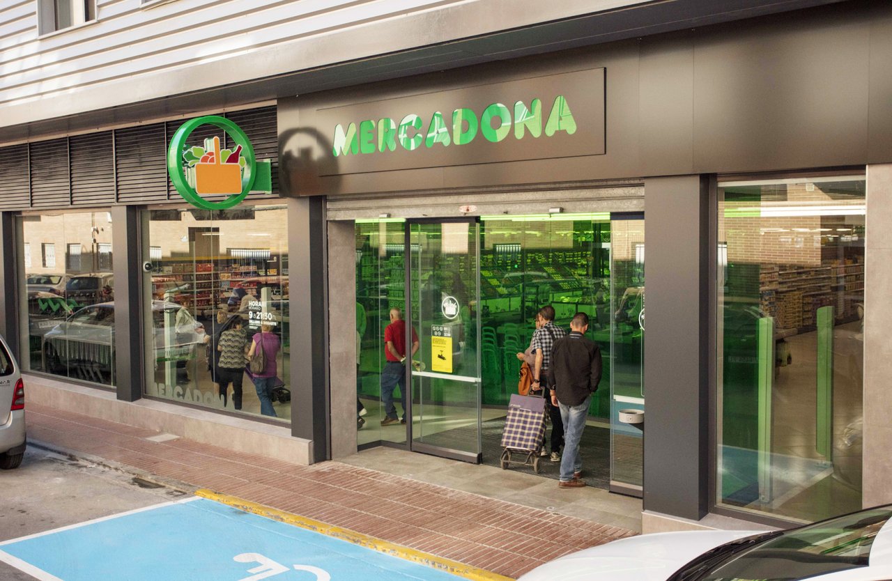 Entrance of Mercadona supermarket in Barcelona with shoppers entering through sliding doors.