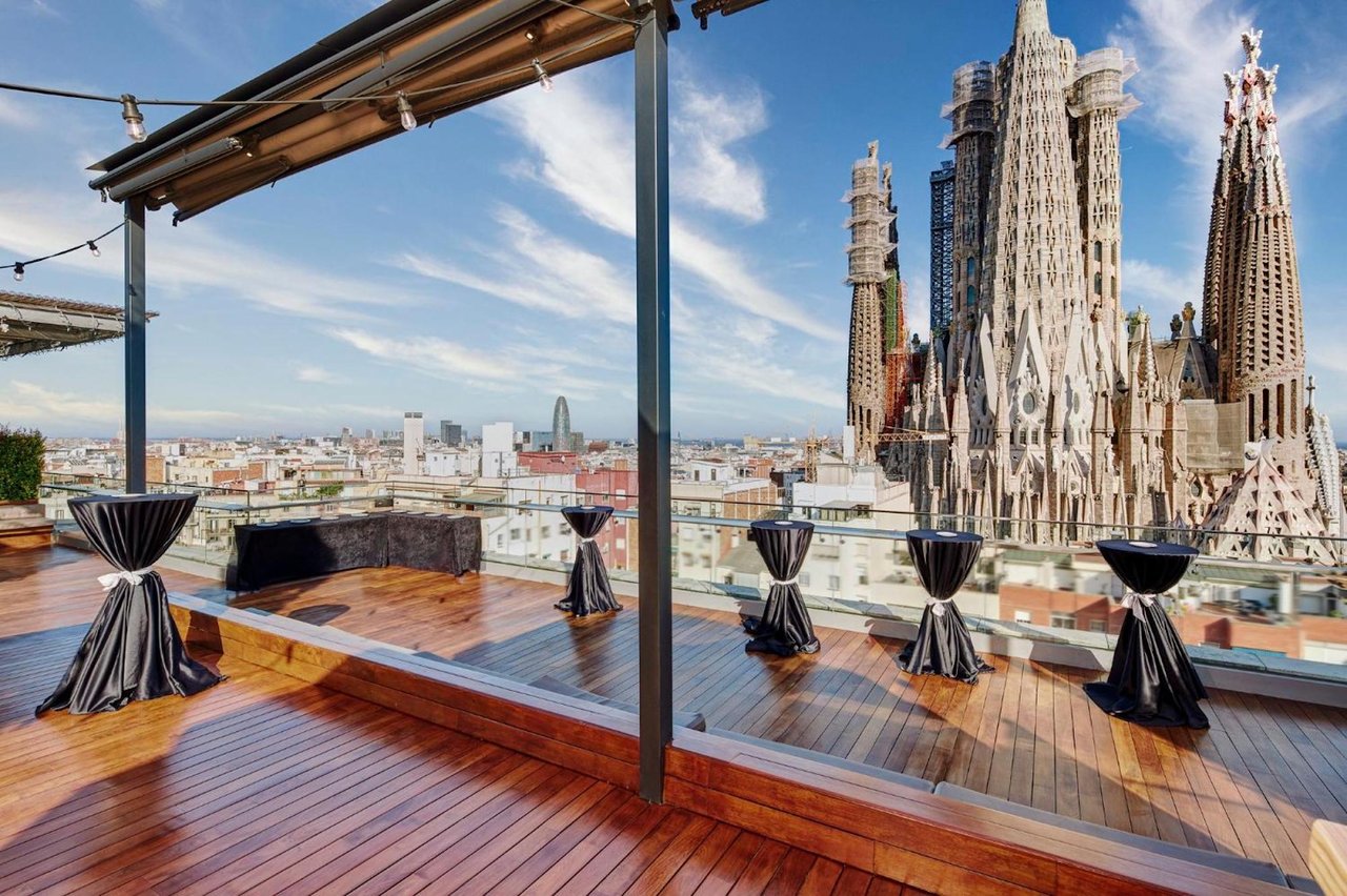 Rooftop terrace at Ayre Hotel Rosellón offering an unparalleled view of La Sagrada Familia and the Barcelona skyline, ideal for events and relaxation.