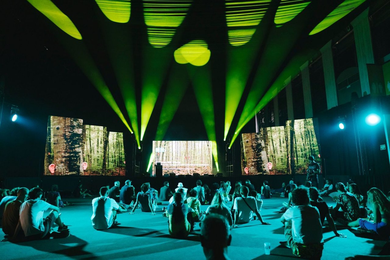 Audience seated indoors at Sonar Festival in Barcelona, watching a visual art performance with green lights.