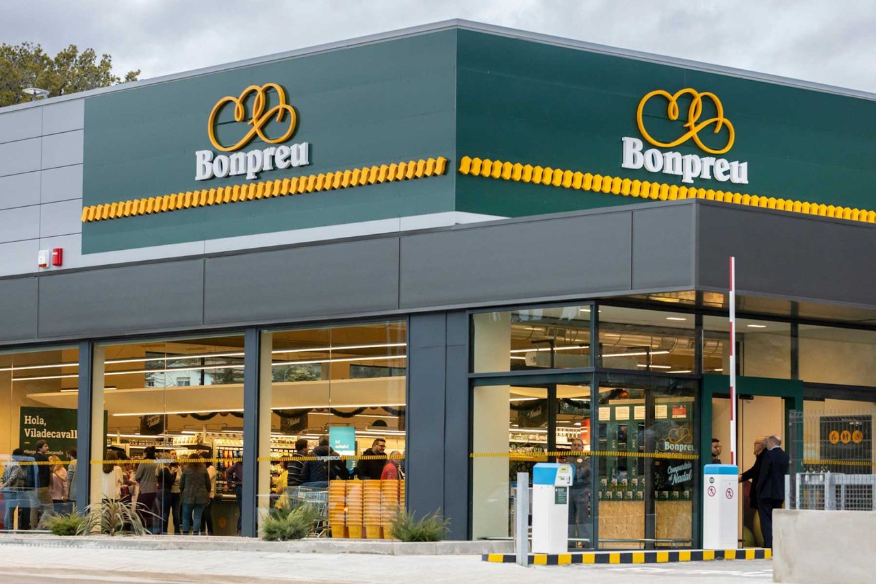 Bonpreu supermarket entrance in Barcelona with green and yellow signage and shoppers inside.