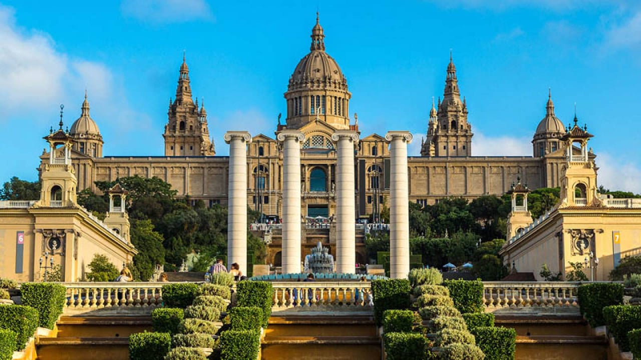 Palau Nacional with four iconic columns in the foreground, a popular landmark in Barcelona.