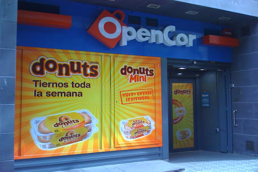 OpenCor store in Barcelona featuring large promotional signage for Donuts and Donuts Mini products.