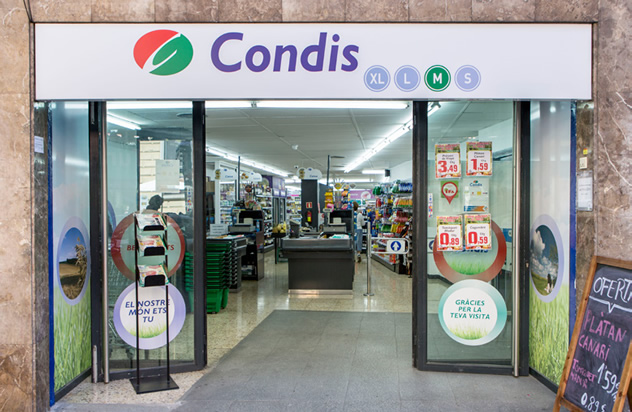 Entrance to Condis grocery store in Barcelona displaying promotions and a view of the checkout area.