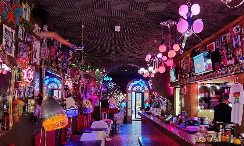 Interior of Priscilla Café in Barcelona, featuring colorful neon lights and vibrant décor.
